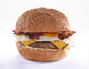 Hamburguesa con huevo y tocino sobre fondo blanco.
