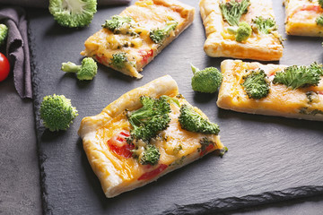 Traditional quiche with broccoli and cheese on slate plate