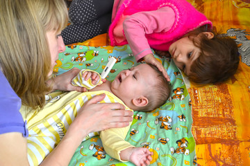 KALININGRAD, RUSSIA. The young woman takes temperature to the sick baby