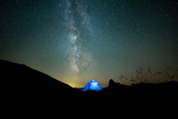 Fototapeta na wymiar Camping under the stars. The Milky Way stretches overhead the tent 