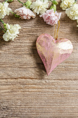 Hearts and carnation flowers on wood