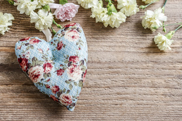 Hearts and carnation flowers on wood
