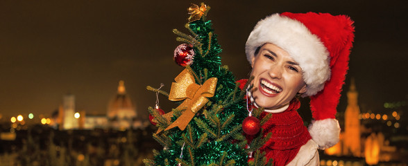 smiling young woman in Florence, Italy with Christmas tree