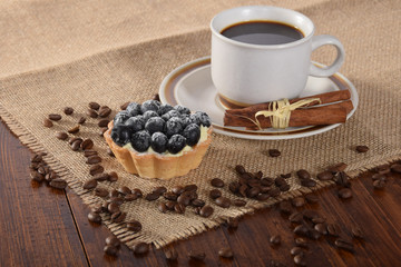 A cup of black vanilla coffee with berry cake