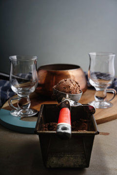 Scoop of chocolate icecream in icecream scoop.