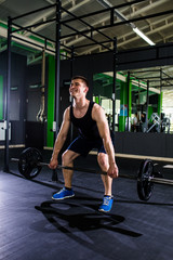 Fototapeta na wymiar Close up of young muscular man lifting weights over gym background