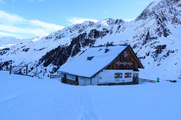 Fototapeta premium Alpine hut Potsdamer Hutte and mountain panorama with snow in winter in Stubai Alps, Austria