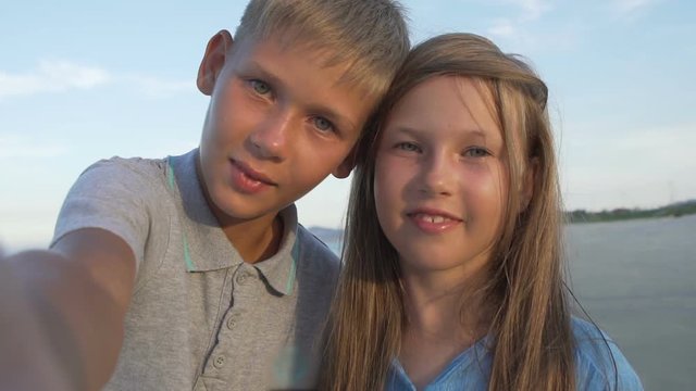 Closeup of blonde little brother and sister taking selfie together