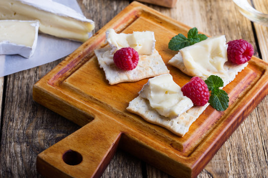 Brie cheese with fresh raspberries and crackers