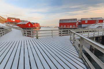 Red cottages-rorbuer. Wooden gangplanks-bridges linking them. A i Lofoten-Sorvagen-Moskenesoya-Nordland-Norway. 0328-2