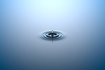 Water drop falling into water surface
