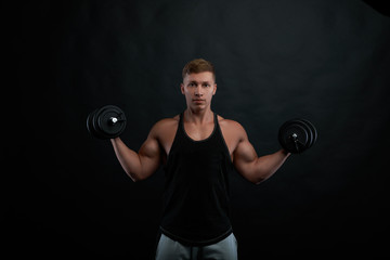 People, sports, fitness, training, workout, strenght and power concept. Portrait of good looking young athletic man working out in gym, lifting barbell, showing his strong chest, shoulders and arms