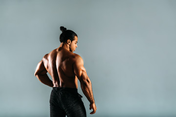 Rear view of young male bodybuilder, studio shot