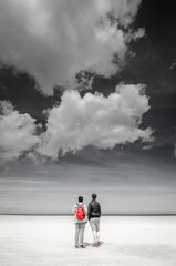 2 people looking at the sky on a beach