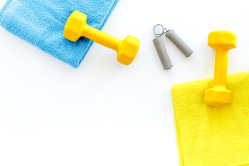 Equipment for fitness. Dumbbells and expander on white background top view copyspace