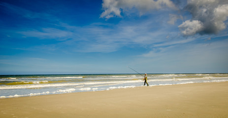 Fisherman walking into the sea