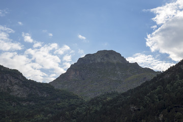 Fototapeta na wymiar Горный пейзаж. Красивый вид на живописное ущелье, облачное небо над высокими горами. Природа Северного Кавказа