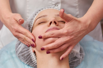 Fototapeta na wymiar Hands massaging face close up. Cosmetic facial massage.