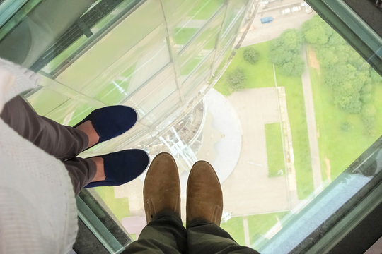Male and female feet on a glass floor at the Ostankino tower in Moscow, Russia
