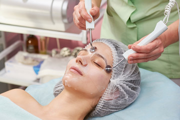 Obraz na płótnie Canvas Microcurrent face treatment, young woman. Caucasian girl, cosmetology procedure.