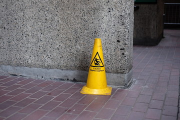 Caution Slippery Floor cone on a brick floor