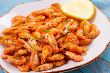 Shrimps with lemon and parsley on white plate