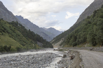 Горный пейзаж, Бурная река в горном ущелье, туман над живописными склонами, белые облака. Природа Северного Кавказа