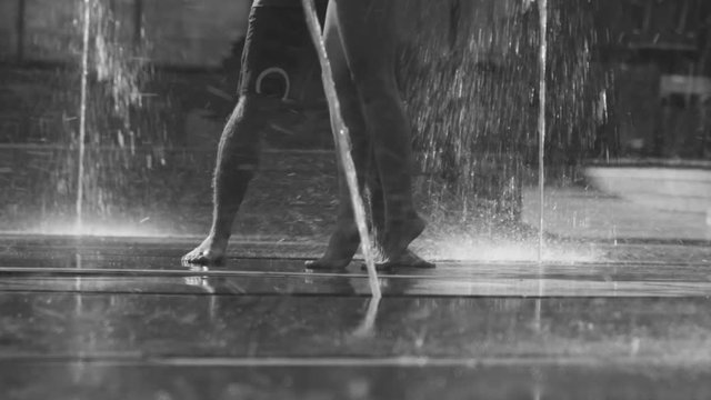 Legs of young couple dancing in the fountain