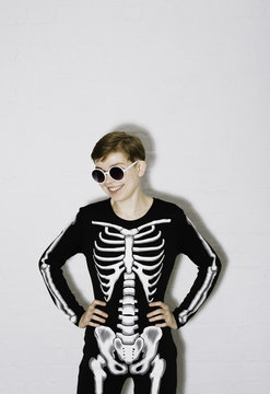 A young woman in the Skeleton costume on the white brick backgroun