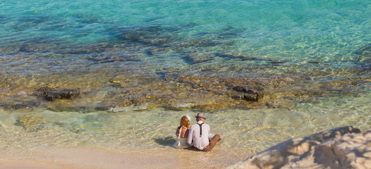 Bride and groom having fun at sandy tropical beach