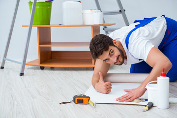 Man doing wallpaper refurbishment at home
