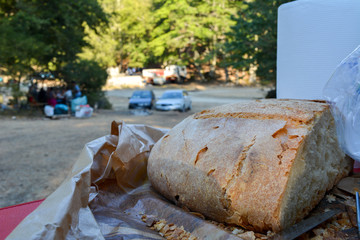 some cut bread, a steel fork and some plastic cups