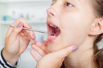 Close-up of little girl opening his mouth wide during treating h