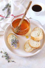 Lavender honey, flowering lavender and slices of baguette