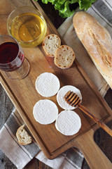 Soft French goat cheese Rocamadour, bread, honey, lettuce and glass of red wine