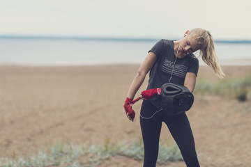 Pretty sportswoman applying her wristwraps before starting her outdoor boxing training