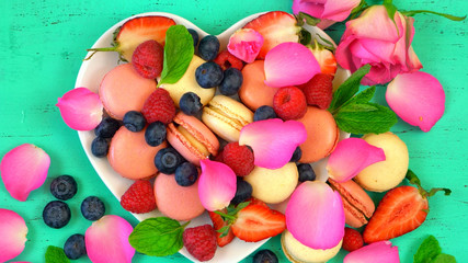 Fototapeta na wymiar Petit Fours presentation of macarons with berries and rose petal