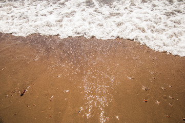 Fototapeta na wymiar Sea beach in with white foam wave