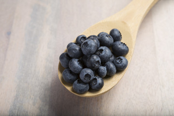 CloseUp Of Fresh Blueberries on a wooden spoon