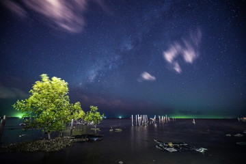 Milky way at beach moving clouds in sky