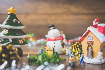 Creative concept with miniature people creating Christmas decorations on a wooden background.