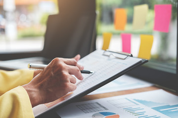 Businesswoman working at his coffee shop and using laptop,  discussing the charts and graphs showing the results of their successful.