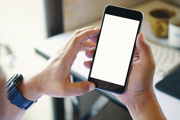 Business man using smartphone in office. Blank screen mobile phone for graphic display montage.