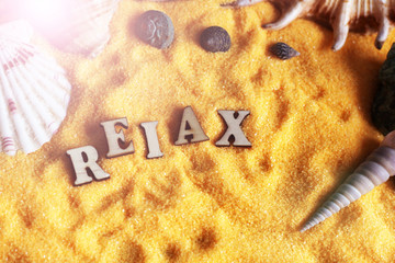 seashells on sand beach, wooden letters, word