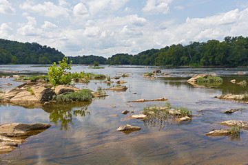 Potomac River near Turkey Island in summer, Virginia, USA. Shallow river waters with rocks on a cloudy day in summer.