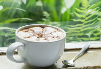 Closeup hot coffee on table with nature background, selective focus