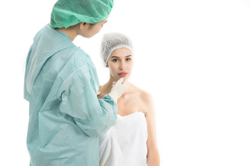 Beautiful young woman is sitting with doctor, examining her face before surgery. Make up beauty concept.