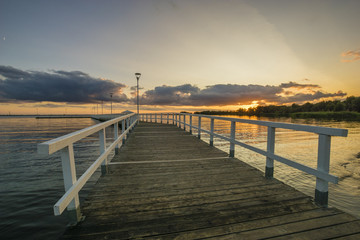Fototapeta na wymiar Sunset on the lake, wooden, white pier