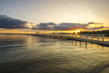 Naklejka na ściany i meble Sunset on the lake, wooden, white pier