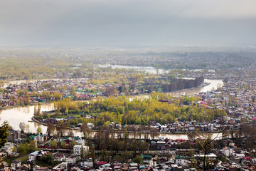 SRINAGAR, INDIA - April 15 2016: Lifestyle in Dal lake, man drive the boat in middle of the Dal lake and mountain background